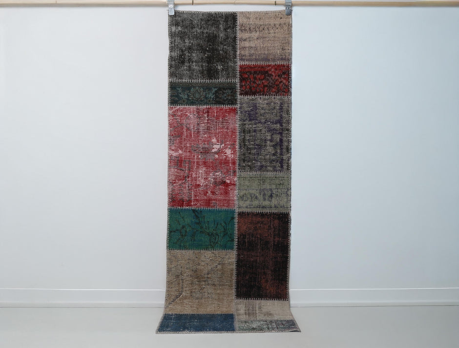 2x7 vintage patchwork runner rug hanging showing multicolor blocks in teal, red and black