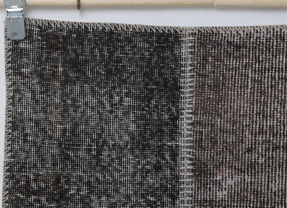 Full vintage patchwork runner rug hanging showing narrow hallway rug in gray brown tones