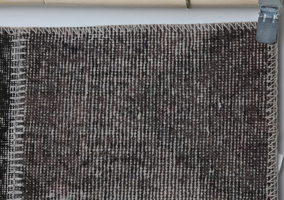 Close-up of handmade wool cotton runner rug showing distressed gray brown weave texture