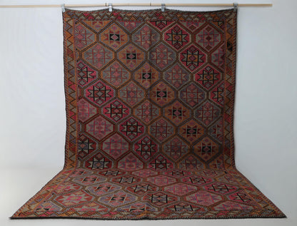 6x10 vintage Turkish flatweave rug hanging showing full red oriental octagon medallion pattern