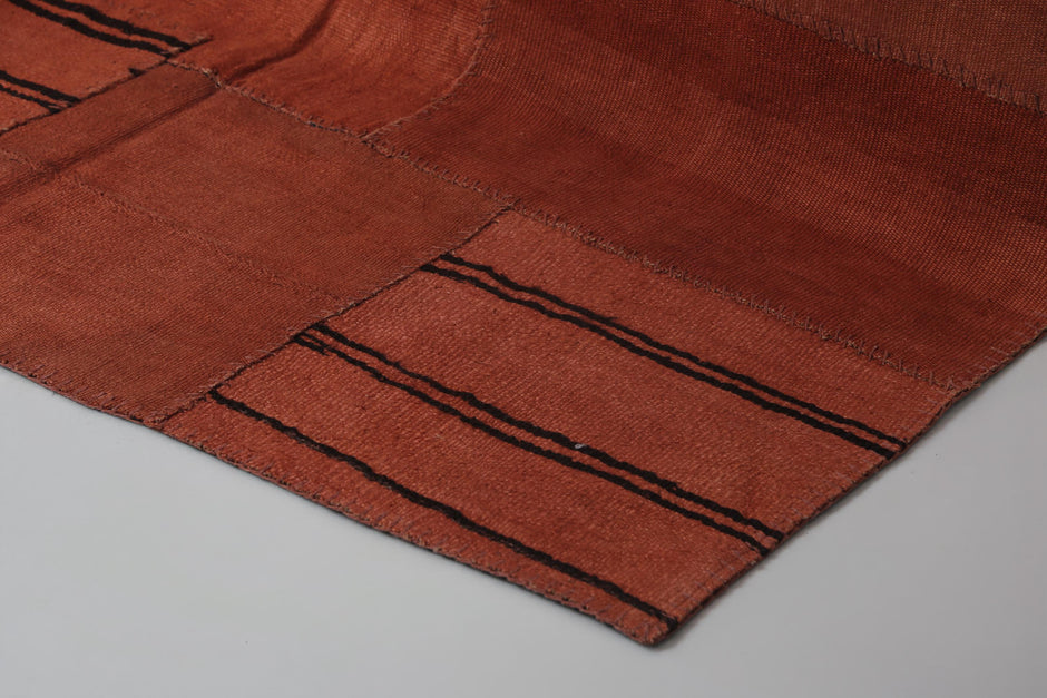 Back side of handmade orange hemp patchwork rug showing weave texture