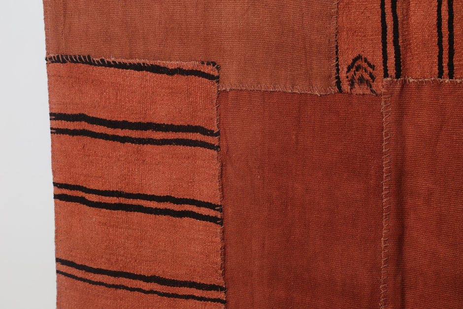 Vintage orange patchwork rug displayed in bohemian living room