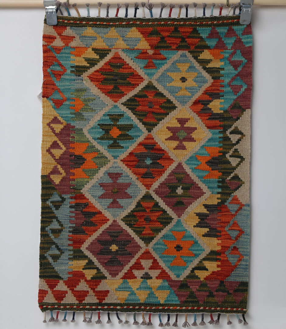 Close-up of vintage Turkish small rug showing turquoise, red, orange and gold diamond design