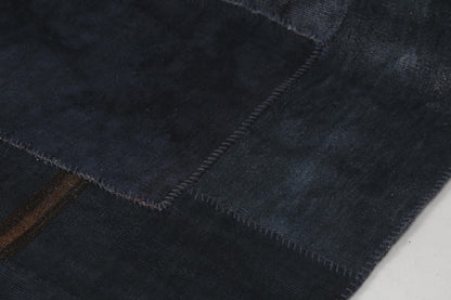 Back side of handmade dark blue hemp patchwork rug showing weave texture