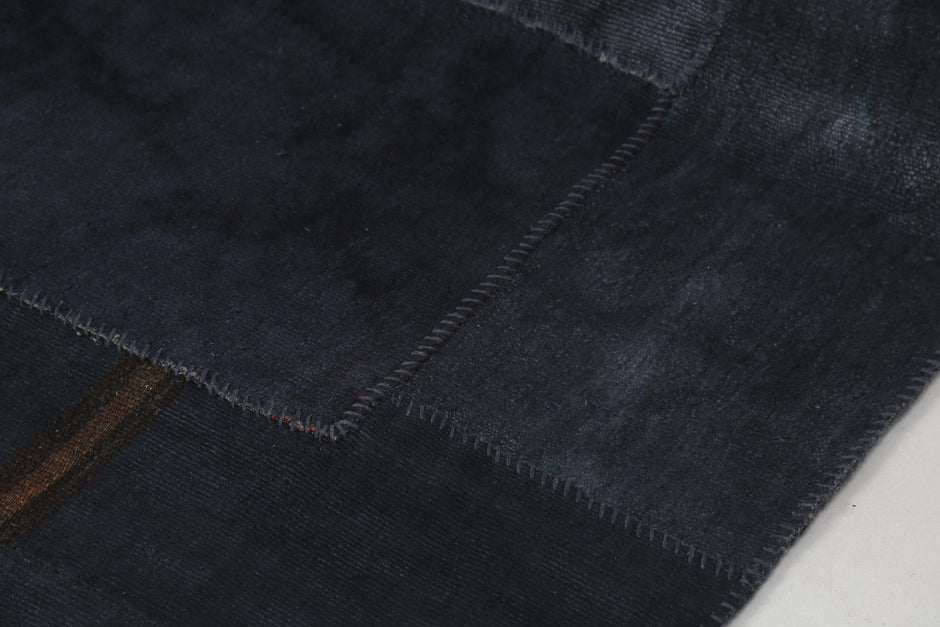Back side of handmade dark blue hemp patchwork rug showing weave texture