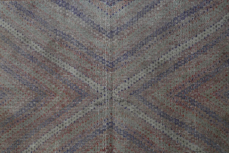 Detail shot of vintage Turkish kilim rug weave showing muted chevron motif in brown and blue