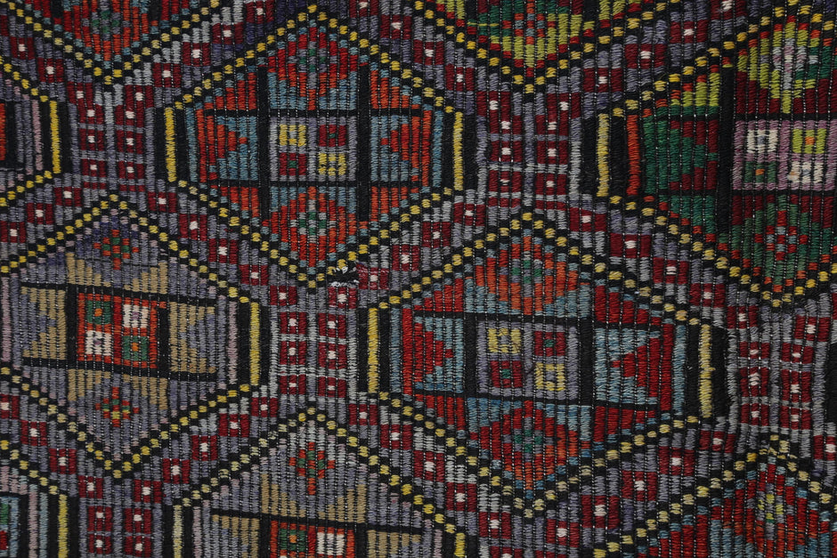 Detail shot of vintage Turkish kilim rug weave showing multicolor boho tribal medallions