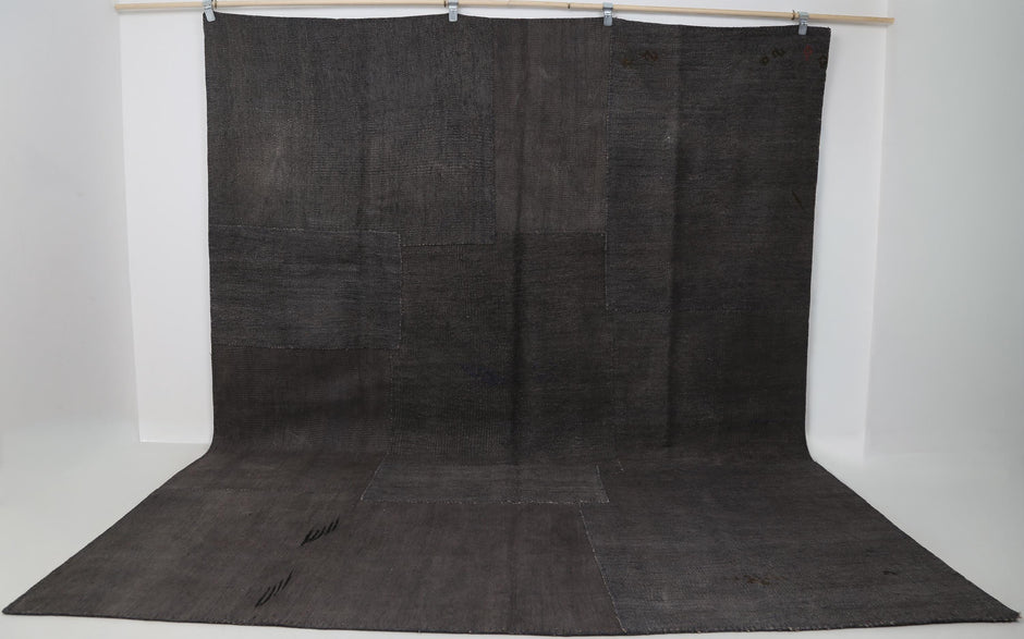 8x10 vintage hemp patchwork rug hanging showing full dark brown oversized panel design