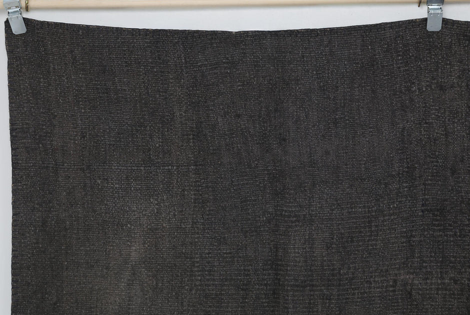 Close-up of vintage Turkish hemp rug texture showing deep brown woven patchwork weave