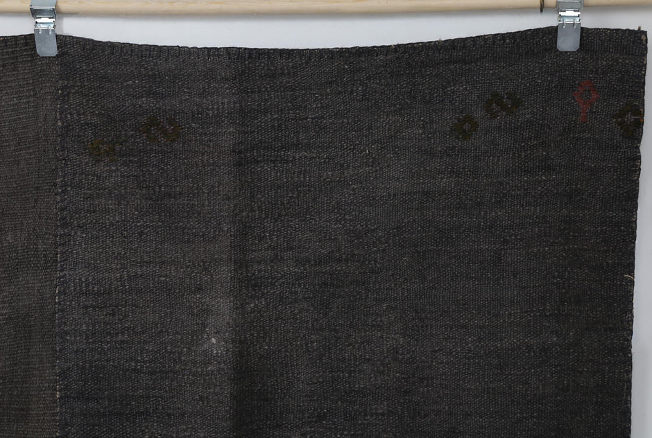 Close-up detail of handmade Turkish hemp rug showing dark brown fabric weave with subtle marks