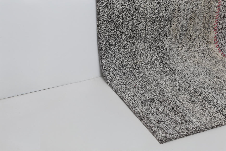 Back side of handmade white and black wool cotton patchwork rug showing weave texture