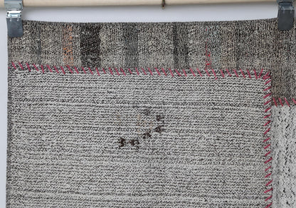 Close-up of contrast stitching detail on white black patchwork rug