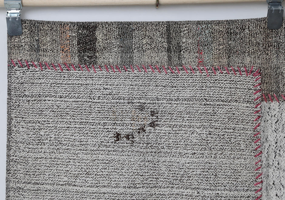 Close-up of contrast stitching detail on white black patchwork rug