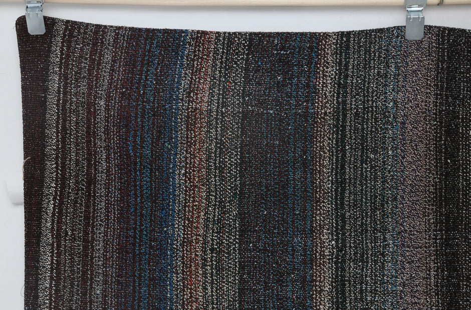 Close-up of charcoal brown stripe detail on dark multicolor kilim