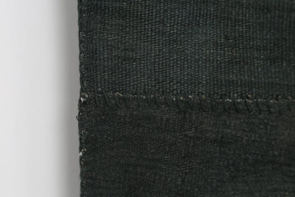 Back side of handmade deep green hemp patchwork rug showing weave texture