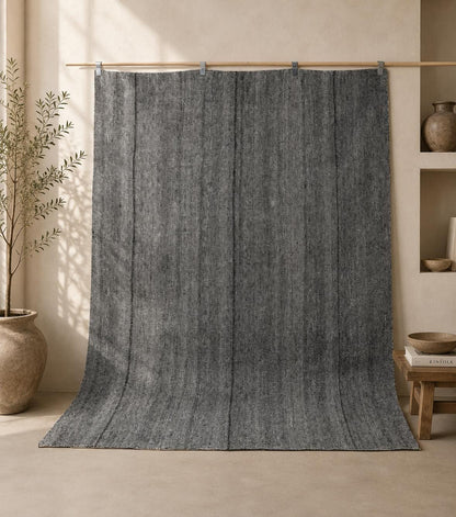 7x7 vintage Turkish flatweave rug hanging in styled room showing charcoal grey thin stripe pattern