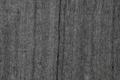 Full vintage Turkish minimal rug hanging with color palette swatches in black, grey and white