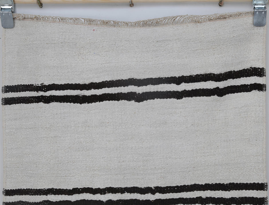 Back side of handmade white and black hemp wool runner showing weave texture