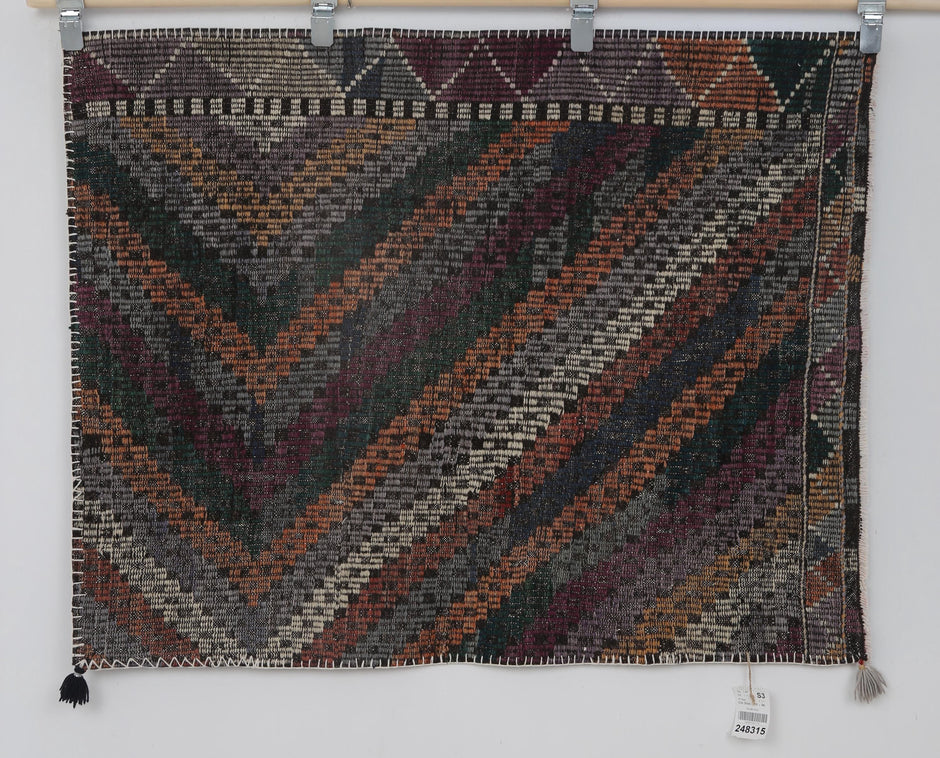 Purple, blue and orange tone detail on handmade wool wall hanging