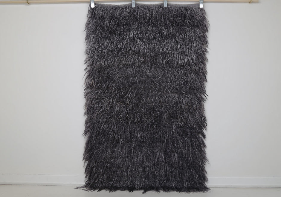  Close-up of flowing wool pile texture on charcoal gray tulu rug