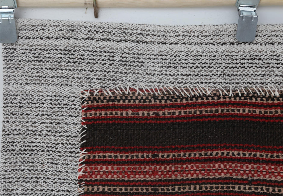  Red and black striped tapestry displayed on gallery wall