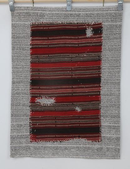  Close-up of hand-stitched detail on red and black striped tapestry