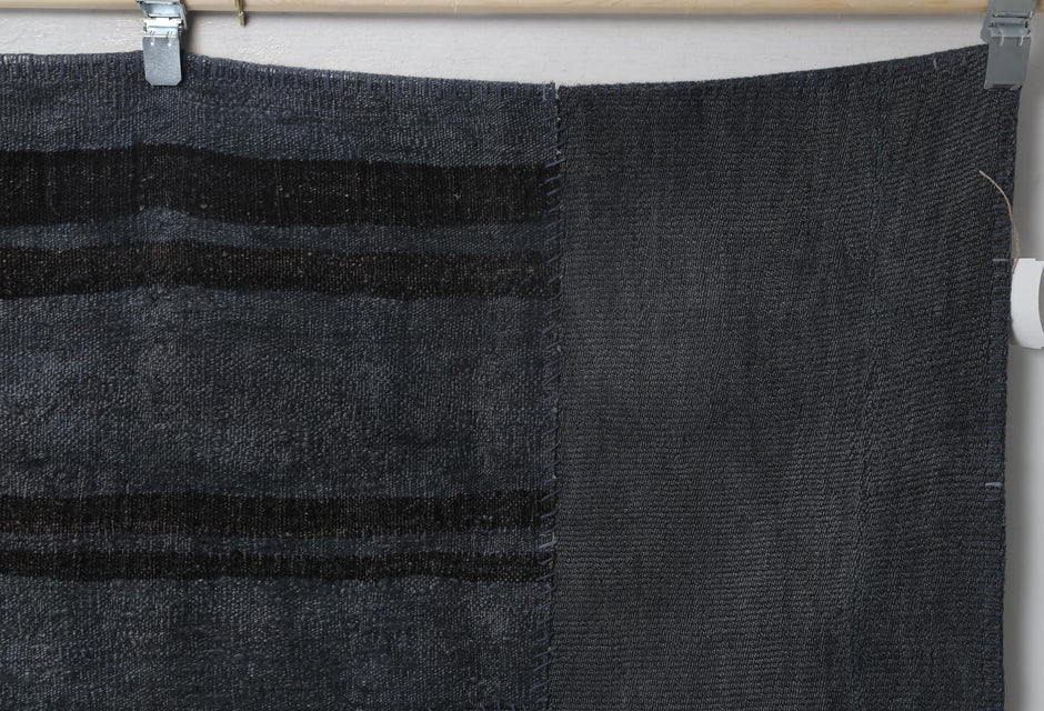 Vintage dark blue patchwork rug displayed in modern office setting