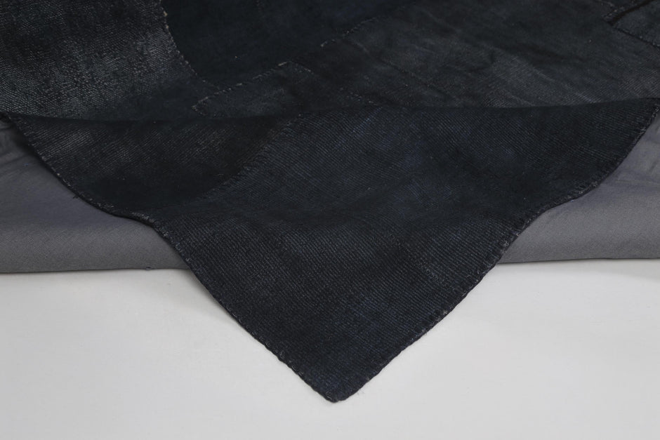 Back side of handmade dark blue hemp patchwork rug showing weave texture