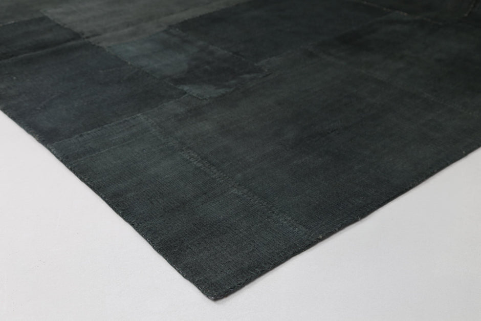 Vintage deep green patchwork rug displayed in modern living room
