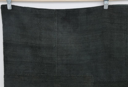 Close-up of tonal patchwork detail on deep green hemp rug