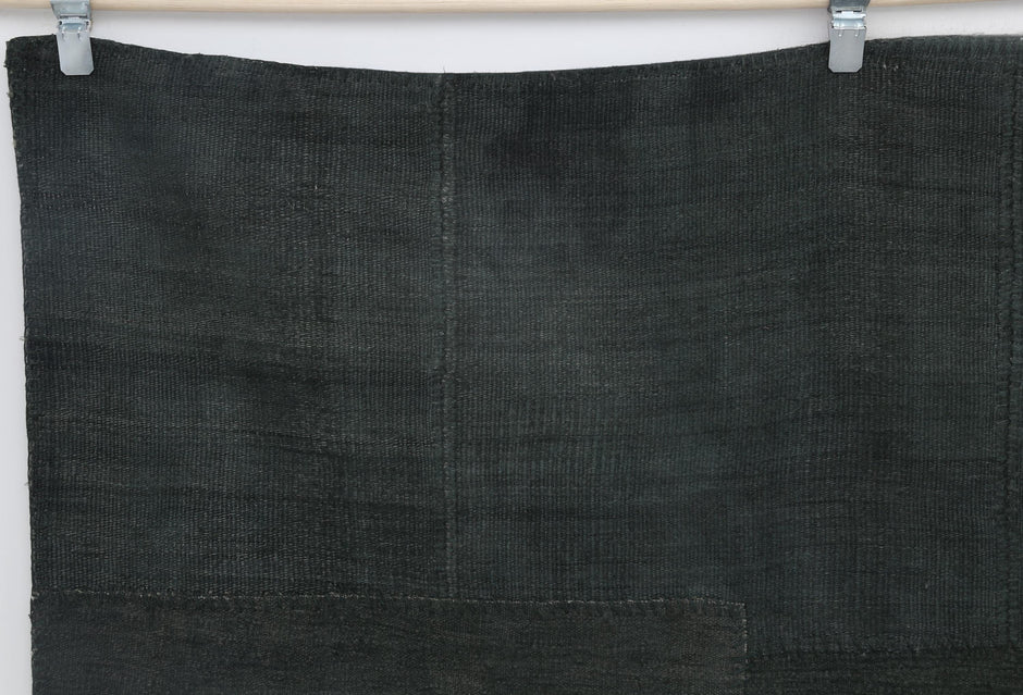 Close-up of tonal patchwork detail on deep green hemp rug