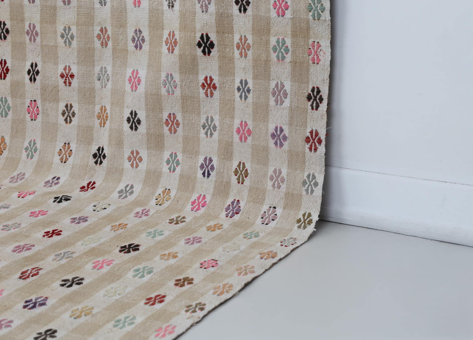 Vintage beige kilim rug displayed in bohemian living room