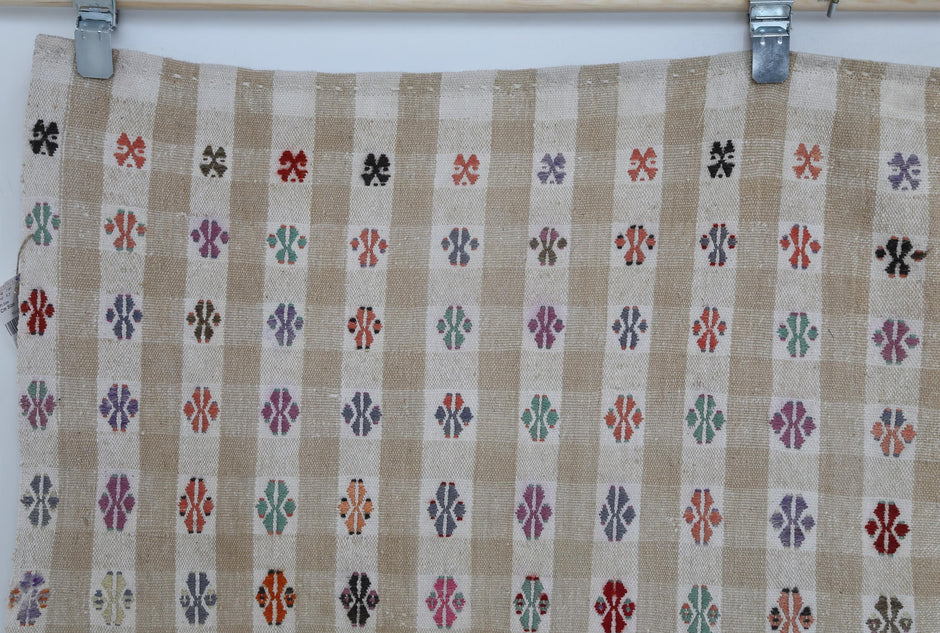 Close-up of tribal motif accent on beige striped kilim rug