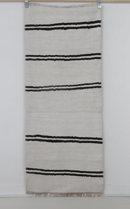 Close-up of black striped detail on white hemp runner rug