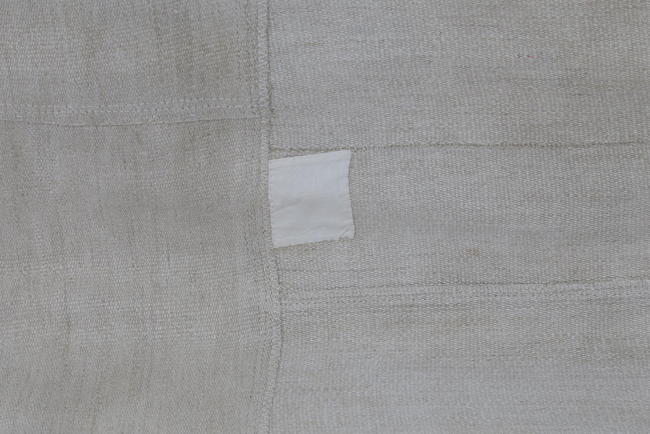 Back side of handmade beige hemp patchwork runner rug showing weave texture