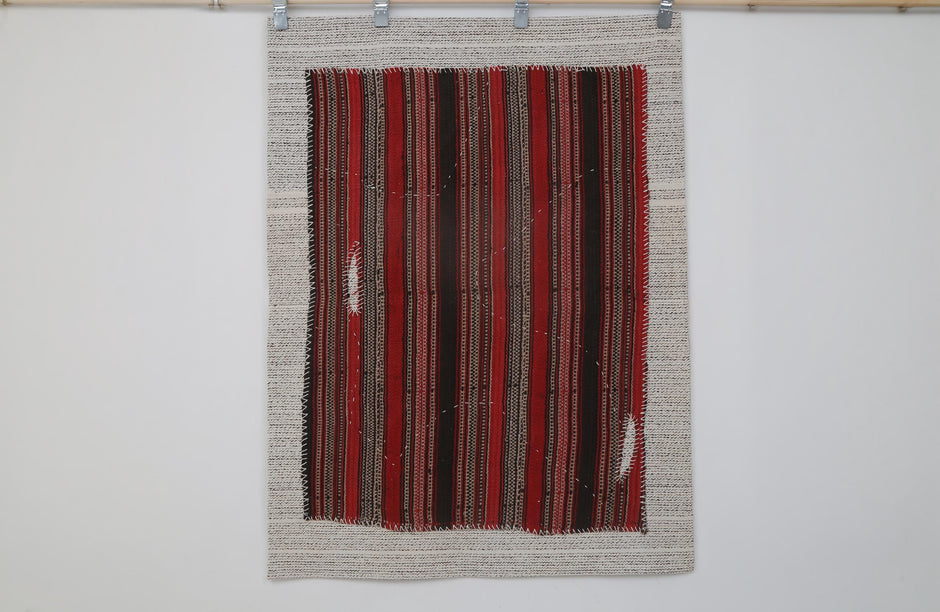  Close-up of multicolor woven detail on red striped tapestry rug