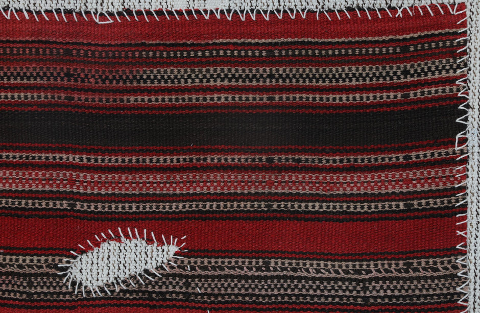 Back side of handmade red and black wool tapestry rug showing weave texture