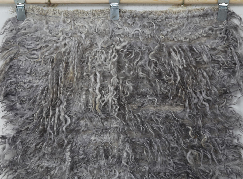 Back side of handwoven gray tulu wool runner rug showing weave base